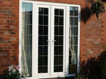 HOLYWELL , NORTH WALES : 2800 White PvcU French doors - Triple glazed - Antigue lead panels U Value .95 pvcu bi folding doors north wales